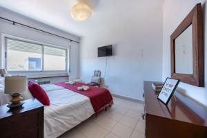 a bedroom with a bed and a desk and a window at Incredible view - T2 Ribeirinha in Portimão +16 photos