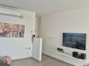 a living room with a flat screen tv on a wall at דירת נופש נווה ים in Kefar HaNo‘ar Niẕẕanim +10 photos