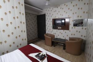 a room with a bed and a tv on the wall at Hotel Yuvraj 5 Mints walking from Rajendra Nagar Metro Station in Ghaziabad