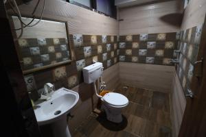 a bathroom with a sink and a toilet and a mirror at Hotel Yuvraj 5 Mints walking from Rajendra Nagar Metro Station in Ghaziabad