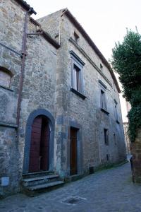 an old stone building with a red door at Palazzo Contino in Bagnoregio