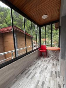 a red chair sitting in a room with windows at Tree Rose Suite in Uzungöl