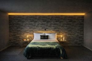 a bedroom with a bed and a brick wall at Glamping Domes in Articlave