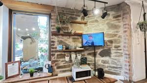 a room with a stone wall with a microwave and a window at Cwmcarn Hotel & Bunkhouse in Cwmcarn