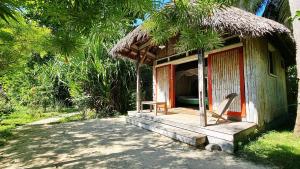 a small hut with a thatched roof at Bungalow Bleu Villa Luna Nosy Be in Nosy Be