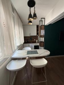 a kitchen with a table and two white chairs at Downtown Apartment Rooms in Tirana
