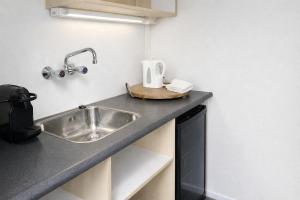 a kitchen counter with a sink in a room at Landgoed Rotermundt in Huijbergen