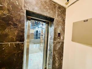 a bathroom with a glass shower with a window at Hotel Oxygen La Vida-Noida Sector 18 in Noida
