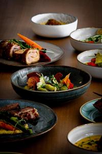 a group of plates of food on a wooden table at Logis Hôtel Le Mas De Jossyl in La Roque-dʼAnthéron +27 photos
