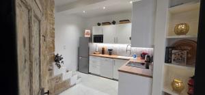 a kitchen with white cabinets and a counter top at Casa Loulou in Saint-Laurent-dʼAigouze