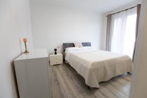 a white bedroom with a bed and a window at Casa Serena in Rivarolo del Re ed Uniti