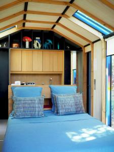 a bed with blue pillows in a room at Designer Cabin With Shared Pool In Bras in Bras