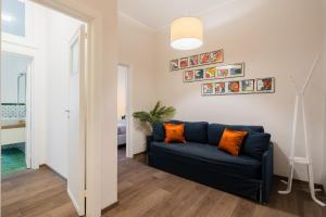 a living room with a blue couch and orange pillows at Mazzini Urban Apartment - Lecce Selection in Lecce