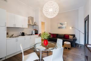 a kitchen and a living room with a glass table at Mazzini Urban Apartment - Lecce Selection in Lecce