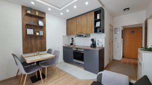 a kitchen with a table and chairs and a kitchen with a stove at Apartman Brankovic in Jagodina