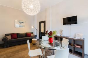 a living room with a glass table and white chairs at Mazzini Urban Apartment - Lecce Selection in Lecce