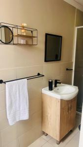 a bathroom with a sink and a mirror at Hidden Bliss Guesthouse in East London +20 photos