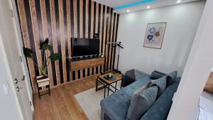 a living room with a blue couch and a tv at Apartman Brankovic in Jagodina