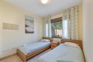 a bedroom with two beds and a window at Spacious 6-bed Apartment in Marina de la Alcaidesa in La Alcaidesa +26 photos