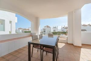 a dining room with a table and chairs on a balcony at Spacious 6-bed Apartment in Marina de la Alcaidesa in La Alcaidesa