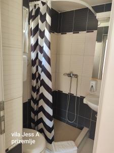 a bathroom with a black and white shower curtain at Vila Konak podno grejanje in Veliko Gradište