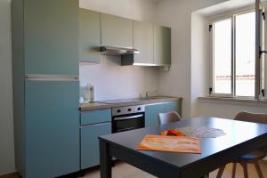 a kitchen with a table and a refrigerator at Nottata de Luna in San Benedetto del Tronto