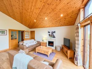 a living room with a couch and a fireplace at Apple Tree Lodge in Errol