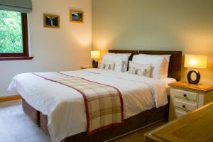 a bedroom with a large bed and a window at Apple Tree Lodge in Errol