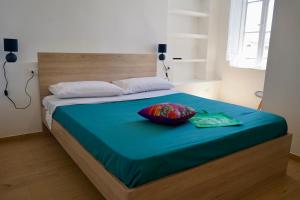 a bed with a blue blanket and two pillows on it at Nottata de Luna in San Benedetto del Tronto