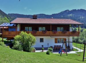 ein Haus mit Balkon und Spielplatz in der Unterkunft Haus Frechen in Berchtesgaden