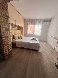 a bedroom with a bed and a brick wall at OM Center Apartments Tirana in Tirana
