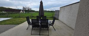 a table and chairs with an umbrella on a patio at Lauberge de Villeron in Savigny-en-Revermont