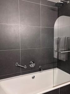 a bathroom with a shower with a white tub at Hotel Orchidee in Aalter