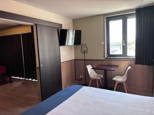 a hotel room with a bed and a table and chairs at Hotel Orchidee in Aalter