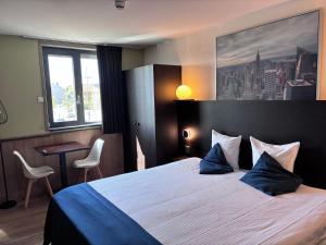 a hotel room with a large bed with blue pillows at Hotel Orchidee in Aalter