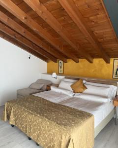 a bedroom with a large bed and a wooden ceiling at Hotel Ristorante Miralago in Garda