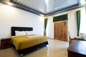 a bedroom with a bed with a yellow bedspread at Pohon Purba Resort & Restaurant in Pulau Lebur +86 photos