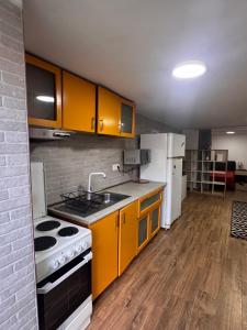 a kitchen with yellow cabinets and white appliances at Studio Park in Craiova