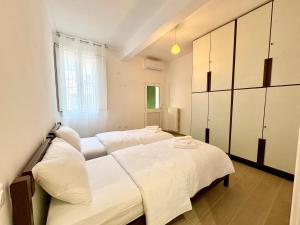 a bedroom with two beds with white sheets at Casa in Centro con Giardino in Imola
