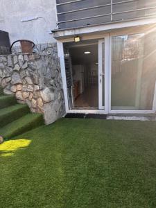 a yard with green grass and a stone wall at Studio Park in Craiova