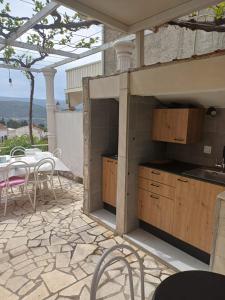 a kitchen on a patio with a table and chairs at Apartmani i sobe Ina in Neum