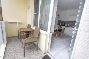 a small apartment with a table and chairs and a kitchen at Apartment DESi in Balchik +4 photos