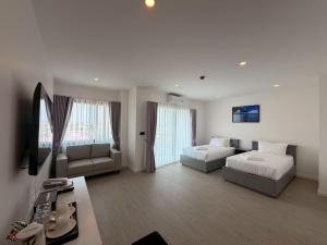 a large living room with two beds and a couch at The View Hotel โรงแรมเดอะวิว นครศรีธรรมราช in Nakhon Si Thammarat