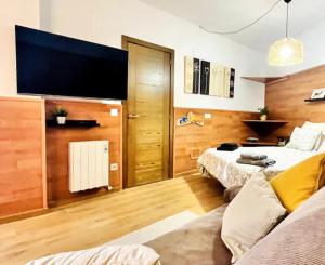 a living room with two beds and a flat screen tv at Estavar in Estavar