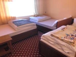 two twin beds in a room with a window at Hotel New Manakamana in Pāti Bhanjyāng