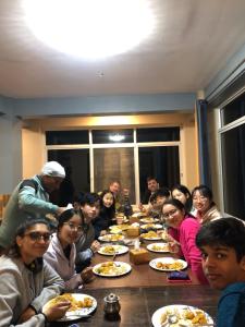 a group of people sitting around a table eating food at Hotel New Manakamana in Pāti Bhanjyāng
