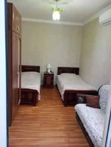 a room with two beds and a couch in it at Tskaltubo Guesthouse Oda in Tsqaltubo +10 photos