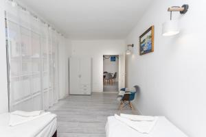 a white room with white furniture and a hallway at Apartment DESi in Balchik