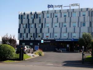 a building with a car parked in front of it at Ibis Budget Le Havre Les Docks in Le Havre