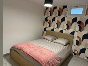 a small bedroom with a bed with a wall at Dream House Paris 5 chambres proche M7et M14 in Villejuif